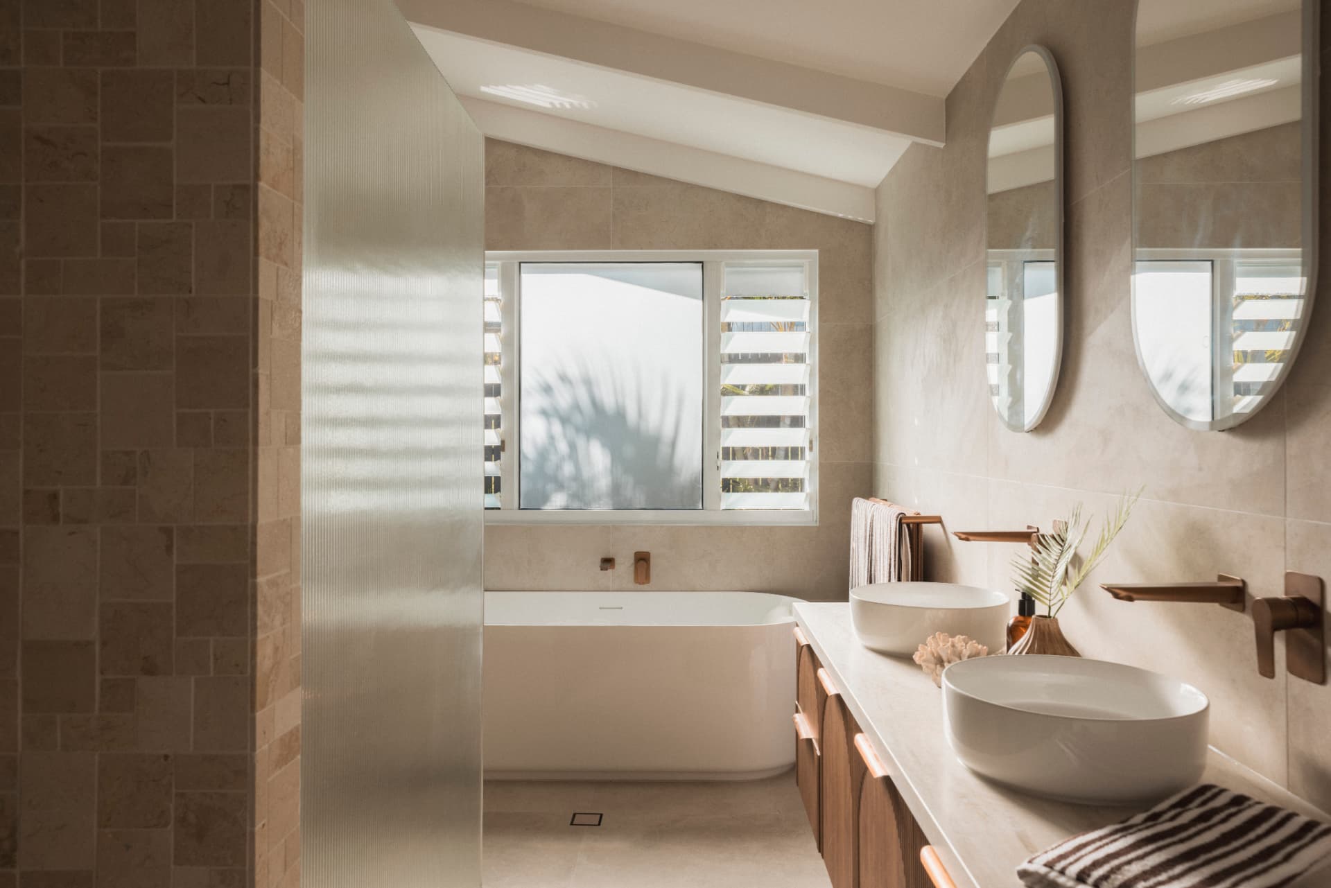 Ensuite with freestanding bath, twin basins and travertine tiling.